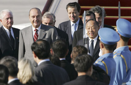 France's President Jacques Chirac (2nd L) is greeted by Chinese Foreign Minister Li Zhaoxing (R) at Beijing airport October 25, 2006. French President Chirac leads an elite business contingent to China on Wednesday, hoping to seize a greater share of the world's fourth largest economy on a 4-day state visit 