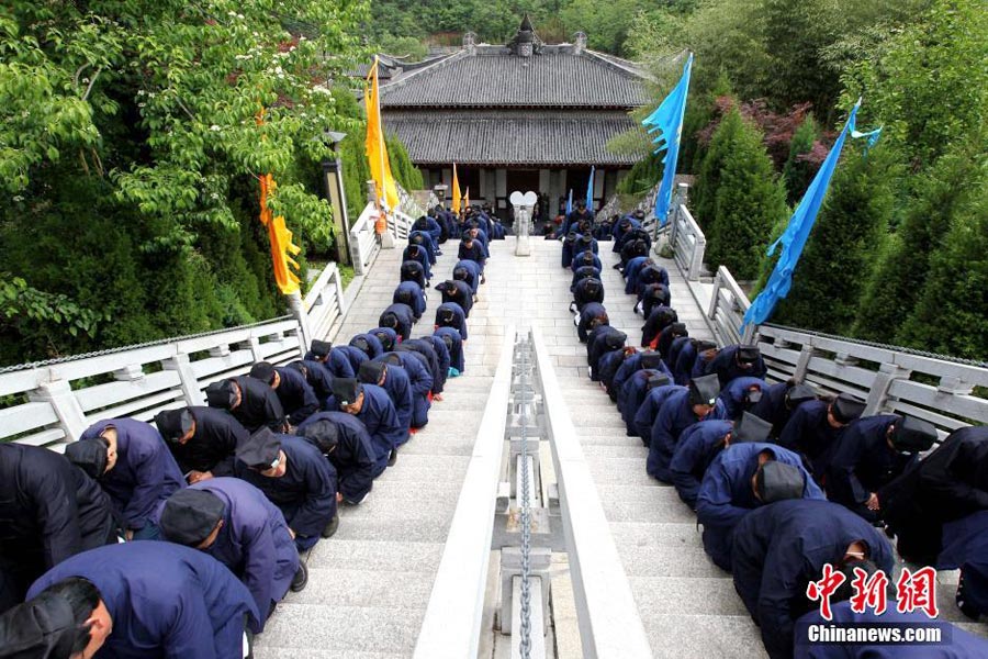 Taoist priests worship their ancestors by kneeling down on stone steps