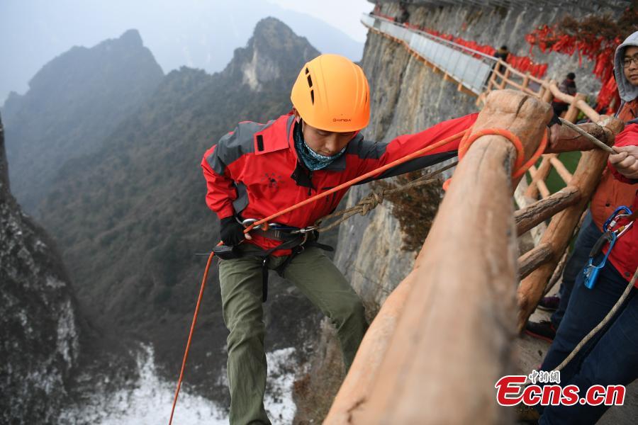 Mountain 'Spiderman' collects garbage at a cliff