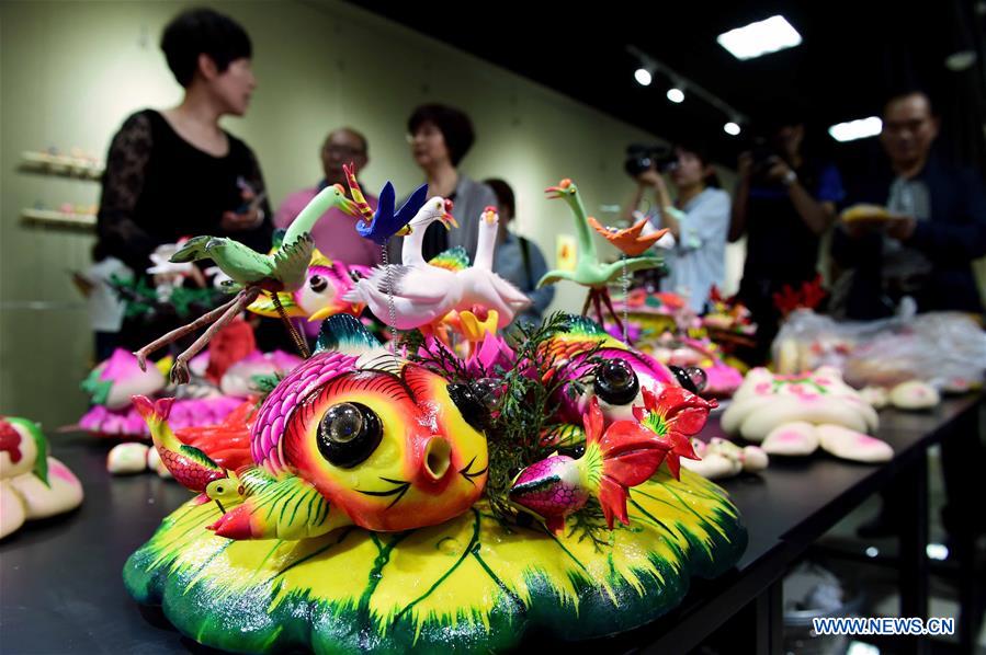 Delicate dough figurine work presented at craft workshop in Shandong