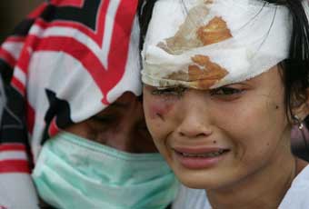 Two women weep as they wait for medical treatment at a miltiary hosptial in Banda Aceh, Indonesia, December 29, 2004, after a tsunami hit the area on Sunday. Indonesian Vice President Jusuf Kalla said on Wednesday the death toll from the weekend quake and tsunami had reached as high as 40,000 people. He said an estimated five percent of the 300,000 population of the Aceh's provincial capital, Banda Aceh, had died. 