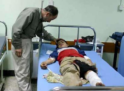 A man visits his son who was injured in a suicide bomb attack at a Shi'ite mosque in the northern Iraqi city of Mosul March 10, 2005. A suicide bomber struck a Shi'ite mosque during a funeral, killing up to 30 people and wounding more than 100. Photo by Namir Noor-Eldeen/Reuters 