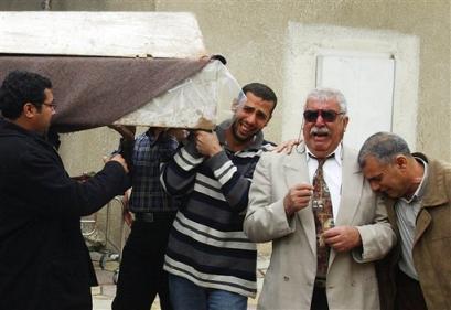 Unidentified relatives at the funeral of one of the bodyguards of Col. Ahmed Abeis, the head of a police station in central Baghdad, who was killed along with his two bodyguards when gunmen in two cars opened fire on the vehicle carrying them in the Saidiyah neighborhood of Baghdad, Iraq Thursday, March 10, 2005. [AP]