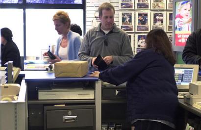 A postal customer Mike Rogers, center, of Bordentown, N.J., mails a package at the post office in Hamilton, N.J., which opened Monday, March 14, 2005, for the first time in more than three years. The post office has been closed since Oct. 18, 2001, after anthrax-laced letters sent to Tom Brokaw, two U.S. senators and the offices of the New York Post passed through here further heightening the nation's insecurity in the weeks after the Sept. 11, terror attacks. [AP]