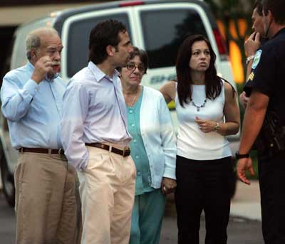 (L-R) Bob Schindler, father of the brain-damaged Florida woman Terri Schiavo, talks with police officers accompanied by his son Bobby, his wife Mary Schindler and his daughter Suzanne in front of the Woodside Hospice where Schiavo is being cared for, in Pinellas Park, Florida, the USA, March 25, 2005. Schiavo completed a week without food or water, sliding closer to death despite a frenetic legal offensive by her parents and efforts by the U.S. Congress and Florida Gov. Jeb Bush to intervene. [Reuters]