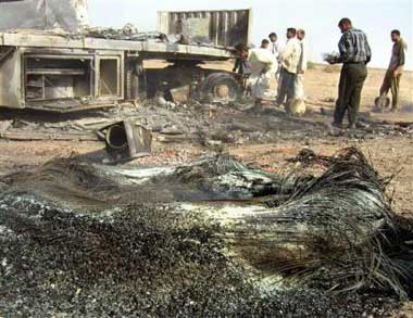 Iraqis gather around the wreckage left behind after a roadside bomb targeted a U.S. military convoy south of Baqouba, Iraq Thursday, March 31, 2005. A car bomb targeted another U.S. convoy north of Baqouba Thursday. (AP