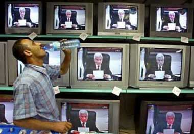 A Palestinian man drinks water as he watches a televised speech by Palestinian President Mahmoud Abbas in Gaza July 16, 2005.Palestinian President Mahmoud Abbas issued a stern warning to militants on Saturday, saying he would not tolerate any further internal fighting or violations of a ceasefire with Israel. 