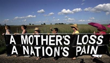 Supporter of 
 Cindy Sheehan march single file on the side of the road leading to President Bush's ranch in Crawford, Texas, Thursday, Aug. 18, 2005. Sheehan has left her vigil to California to be with her mother who suffered a stroke. (AP