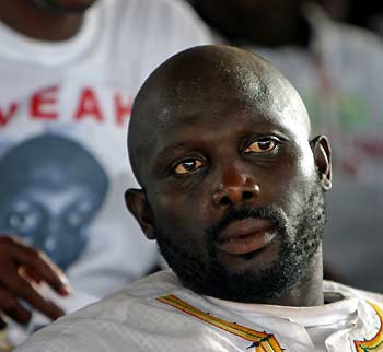 Presidential hopeful George Weah sits in his headquarters during a campaign rally for the Congress for Democratic Change (CDC) at his headquarters in Monrovia, Liberia October 8, 2005. Tens of thousands of supporters of the Liberian presidential hopeful brought Monrovia to a standstill on Saturday as the millionaire soccer star held a final campaign rally before Liberia's first post-war elections.