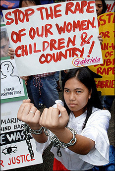 A protestor wearing a Philippines flag and symbolically chained during an anti-US protest near the US embassy in Manila, 09 December.