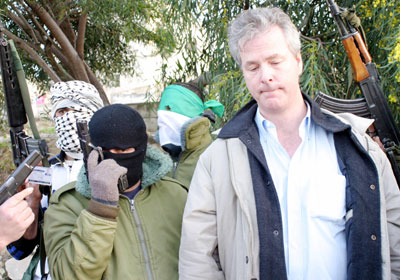 Palestinian militants stand with U.S. citizen Douglas Johnson, an English teacher at the Arab American University, moments after he was kidnapped near the West Bank town of Jenin March 14, 2006. Johnson, kidnapped by Palestinian gunmen in the West Bank on Tuesday has been freed, militants and the school that employed him said. 