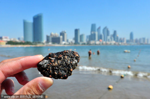 E China beach covered by unknown black substance