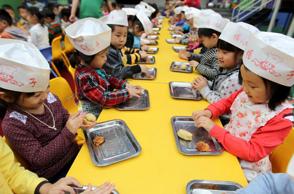 Children learn to make festival delicacy