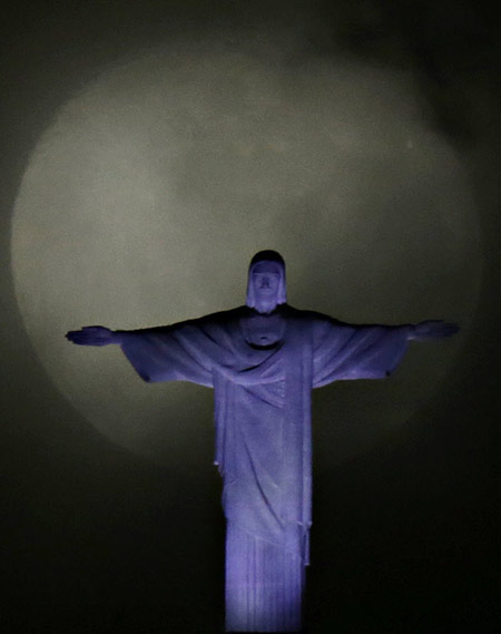 Big moon pictured with Christ the Redeemer statue