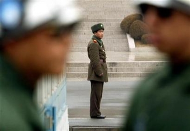 A North Korean is seen between two South Korean soldiers at the truce village of Panmunjon in a file photo. North Korea wants talks with Washington over its apparent preparations for a missile test, Yonhap news agency said on Wednesday. [Reuters]