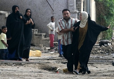 A woman is comforted by a relative at the spot her husband was killed in a car bomb blast in Aqaba bin Nafea Square in central Baghdad, Iraq, Wednesday Nov. 1, 2006. A total of five people died in the blast and 10 others were wounded. (AP