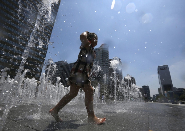 Girl plays at fountain to cool down in Seoul